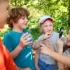 Children with magnifying glass and jar in nature doing nature scavenger hunt for kids