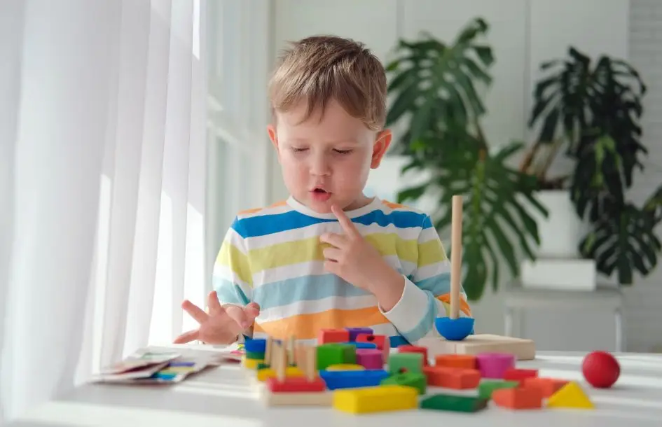 Young boy playing with colorful blocks while learning about colors